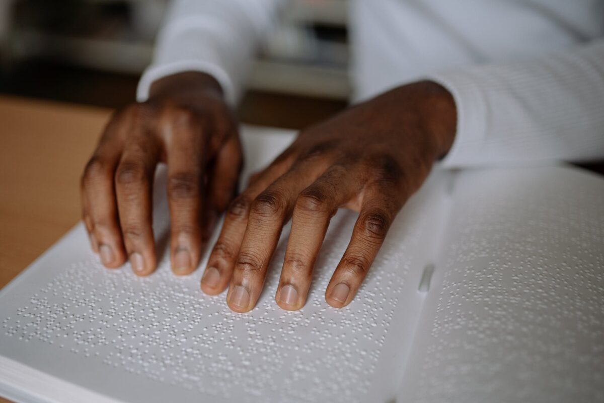 close up of a person reading a braille book