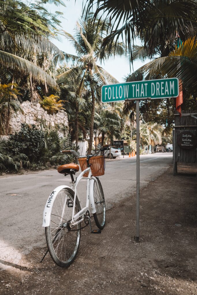 Bike next to a 'Follow that dream' roadsign.